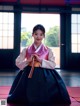 A woman in a pink and black hanbok is posing for a picture.