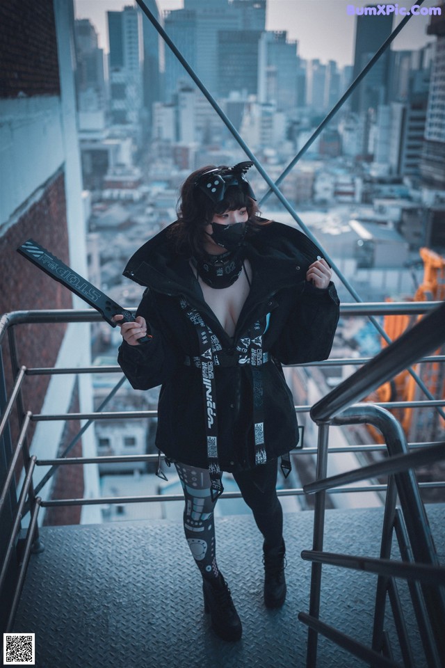 A woman standing on top of a building holding a knife.
