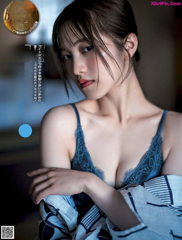 A woman in a blue lingerie is posing for the camera.