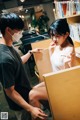 A man and a woman wearing face masks in a library.