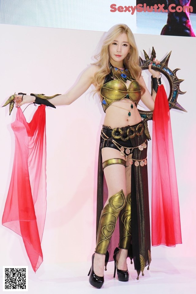 A woman in a costume holding a sword and a red scarf.